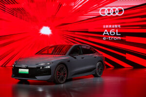 2026 Audi A6 e-tron Sportback electric sedan in gray parked at a charging station showing LED headlights and aerodynamic design