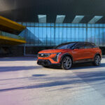 2026 Cadillac Optiq AWD compact electric SUV in Monarch Orange on road