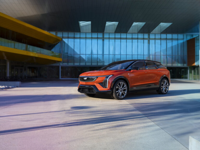 2026 Cadillac Optiq AWD compact electric SUV in Monarch Orange on road