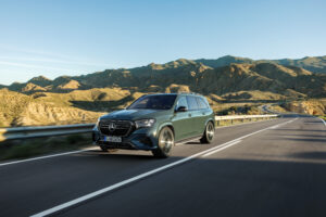 2027 Mercedes-Benz GLS parked in front of a modern luxury hotel featuring sleek LED headlights, large premium alloy wheels, elegant full-size SUV styling, and a bold chrome front grille.